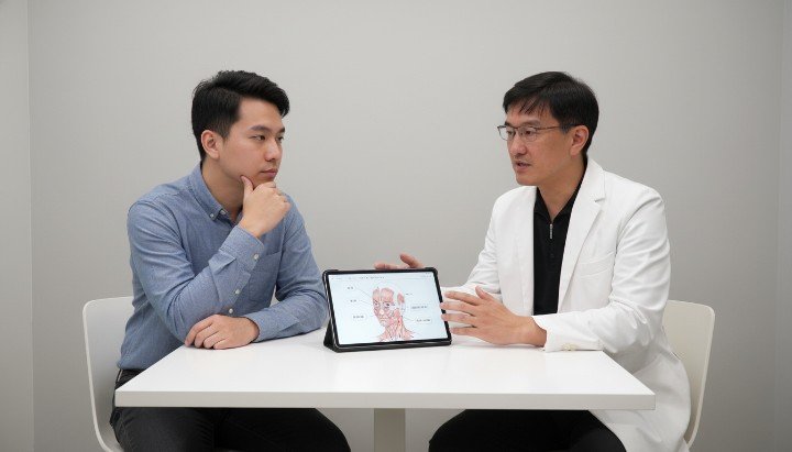 穿著白袍的吳紹琥醫師正在專業診間說明肉毒品牌。 男性臉部特寫標示出適合注射肉毒品牌的肌肉區域。 擺放在質感托盤上的不同肉毒品牌原廠藥瓶與針具。 呈現自然俐落男性下顎線條與健康皮膚的肉毒品牌成效。